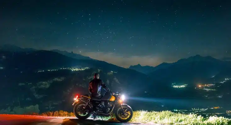 man siting on motorcycle at night