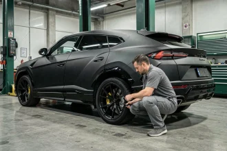 Technicien inspectant les freins d'une Lamborghini Urus dans un atelier de service haut de gamme