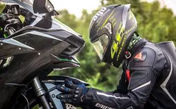 person wearing helmet while holding motorcycle