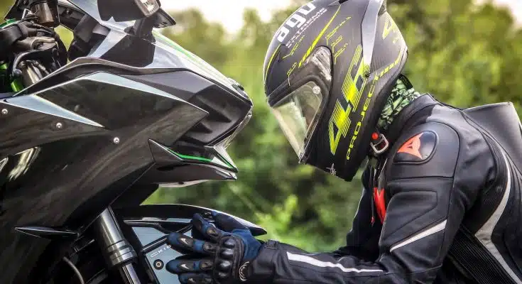 person wearing helmet while holding motorcycle